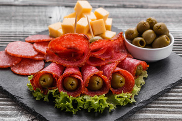delicious sliced salami on a stone plate wooden background