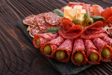 Cold smoked meat plate on a rustic wooden background