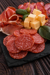 Cold smoked meat plate on a rustic wooden background