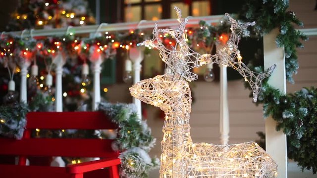 Christmas decoration of the house porch with glowing deer