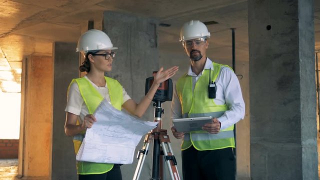 A male and a female engineers in the middle of a discussion in the building house