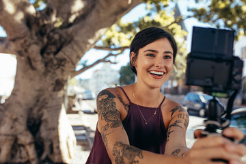 happy young woman vlogging outdoors