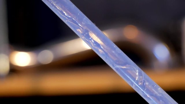 Liquid flows through a transparent plastic tube during the production of alcohol