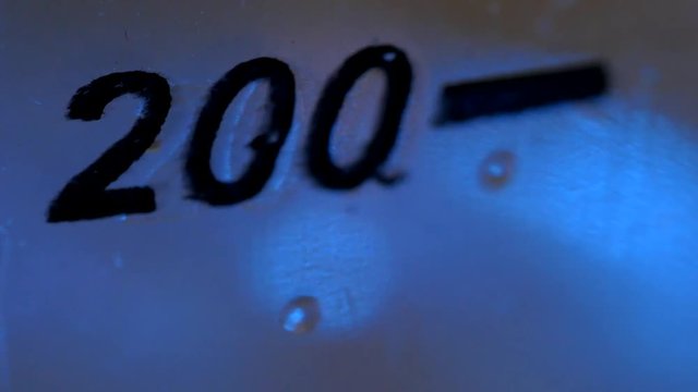 Close-up of a can with a “200” mark during home alcohol production