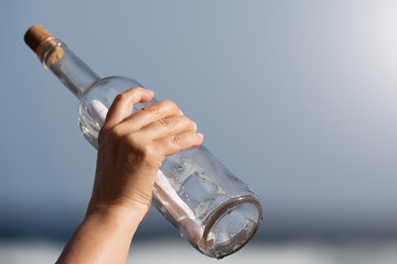Throwing a message in a bottle hand detail
