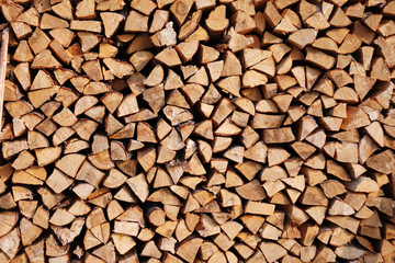 Chopped wood laid in a woodpile to dry for the winter. Wood texture.