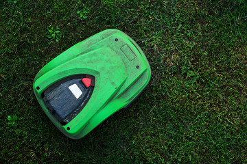 broken robotic lawnmower with a lot of dust in home garden