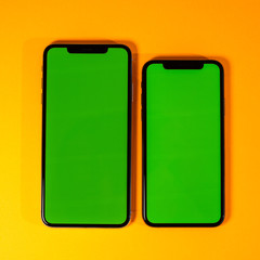 Green chroma key on new mobile smartphne as hero object on bright glamorous modern neon pop orange background - smartphone ready to insert your app square image