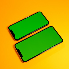 Green chroma key on new mobile smartphne as hero object on bright glamorous modern neon pop orange background - smartphone ready to insert your app
