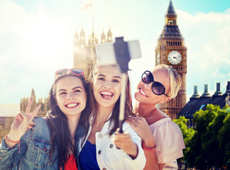 summer vacation, holidays, travel, technology and people concept- group of smiling young women...