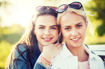 summer vacation, holidays, friendship and people concept - happy smiling young women or teenage girls outdoors