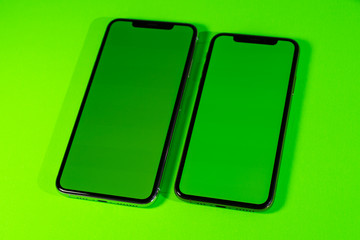 Blank green chroma key on modern smartphone mobileas hero object on bright glamorous modern neon pop green background - smartphone telephone ready for your app
