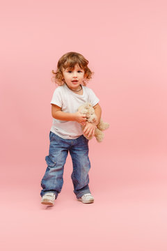 Portrait of happy joyful beautiful little boy, studio shot on pink