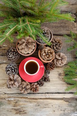 Coffee cup, Fir branches, cones on rustic wooden background. Christmas holiday concept. festive winter season, advent time. top view. template for design