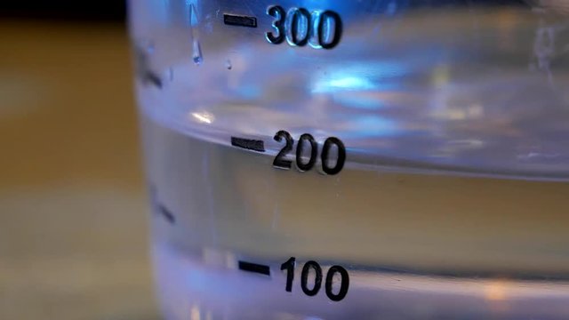 The liquid fills the measuring tank during chemical experiments close-up
