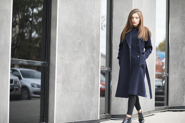 Obraz premium Beautiful girl in a coat in business downtown 