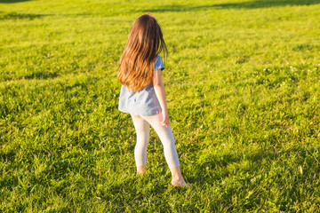 Little happy girl having fun in a summer park.