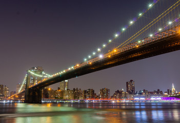 Fototapeta na wymiar Long time exposure of New York City Brooklyn Bridge at night viewed from Brooklyn Bridge park