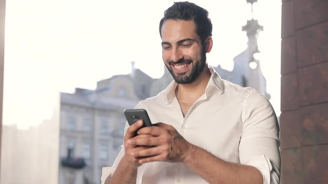 Man Using Mobile Phone Outdoors At Sunny Day