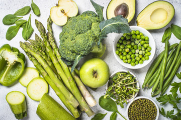 Green food assortment on light stone background. 