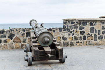 Fototapeta na wymiar old historic cannon in front of the harbour wall