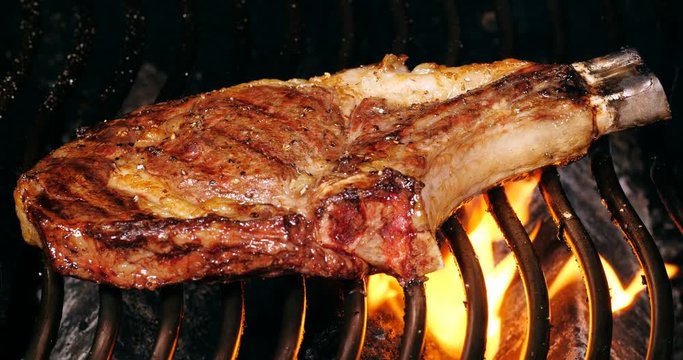 C4K closeup shot of the juicy beef steak on a barbecue grill