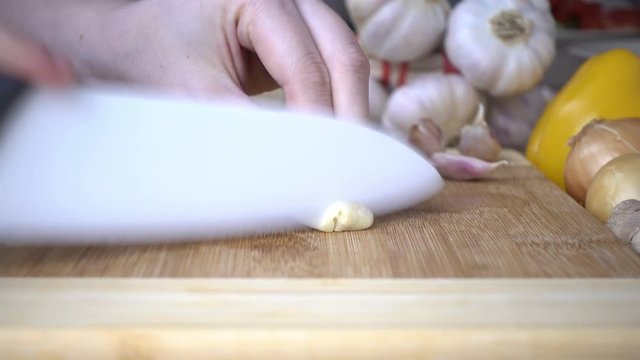 Smashing and Slicing garlic on cutting board. Cooking concept