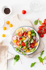 healthy colorful vegan tomato salad with cucumber, radish, onion