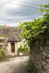 Fototapeta premium Village street with ancient walls and houses in village of Najac, Aveyron, France