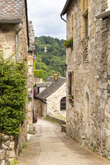 Fototapeta na wymiar Village street with ancient walls and houses in village of Najac, Aveyron, France