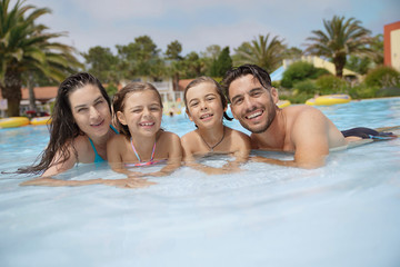 Obraz premium Cheerful family in hotel swimming-pool