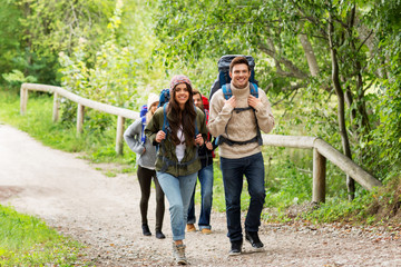 travel, tourism, hiking and people concept - group of happy friends or travelers with backpacks