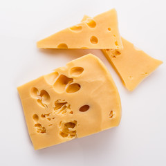 Piece and slices of cheese on a white background