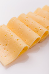 Piece and slices of cheese on a white background