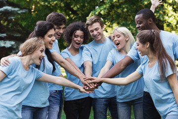 Young happy volunteers outdoor meeting at park