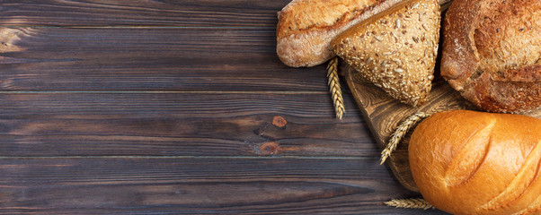 Homemade loaf of wheat bread baked on wooden background. banner for advertising and design, promo...