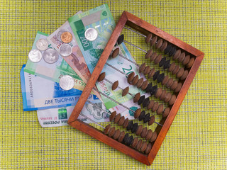Wooden abacus and Russian cash, coins and banknotes. The concept of calculating money.