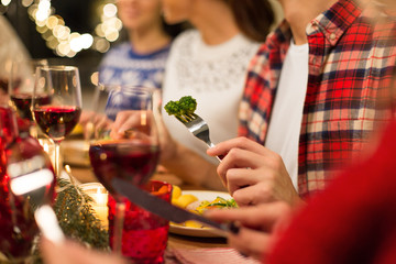 holidays, food and celebration concept - close up of friends having christmas dinner and eating