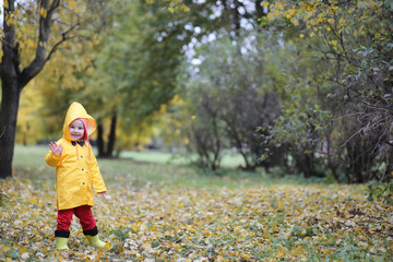 A child in a raincoat for a walk outside