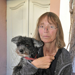 frau hält kleinen hund im arm
