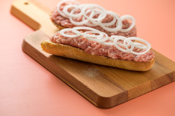 Schweinemett Brötchen mit Zwiebeln auf Holzbrett