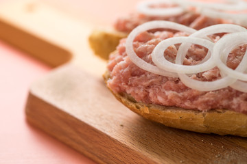 Schweine Mettbrötchen mit Zwiebeln auf Holzbrett