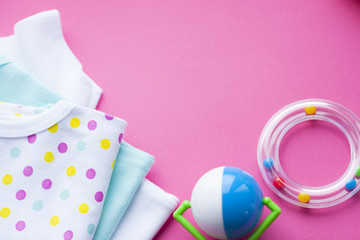 Baby yellow booties. Children's shoes and toys on pink background. Newborn.