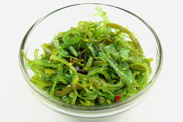 wakame salad with sesame in a small glass bowl isolated