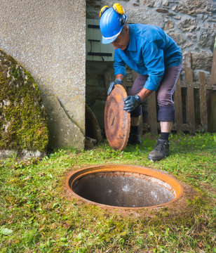 A worker opens a manhole in to descend underground