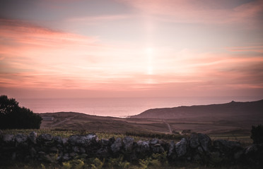 Epic and dramatic sunset in Galicia Spain on a clear day with orange and magenta colors and a nice view over the sea