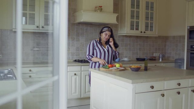 Plump girl is cooking in the kitchen