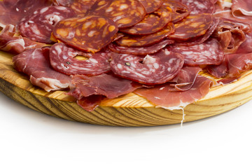 Typical spanish food with ham and sausage on a wooden plate