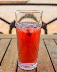 glass with red drink on a pub table outside