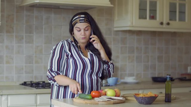 Plump girl is cooking in the kitchen